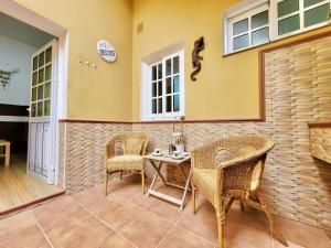 un patio con tavolo, sedie e lucertola sul muro di Casa Anita by TOR a Punta del Hidalgo