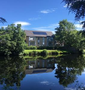 a house with solar panels on top of a lake at Beautiful Riverside Holiday Home in Callander