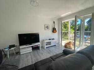 a living room with a couch and a flat screen tv at Beautiful Riverside Holiday Home in Callander