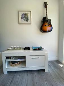 un armadietto bianco con una chitarra sul muro di Beautiful Riverside Holiday Home a Callander