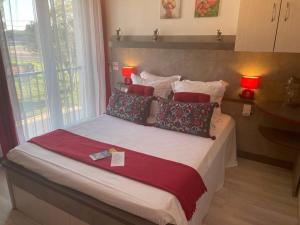 a bedroom with a large bed with pillows at Hôtel Le Méditerranée in Hyères