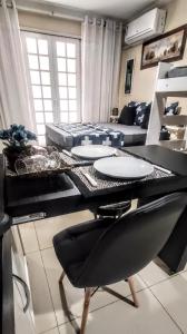 una mesa de comedor con platos en la sala de estar en Central Praias Suíte 5, en Cabo Frío