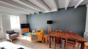 a dining room with a wooden table and chairs at Maison de pêcheur rénovée avec cour proche du port in Les Sables-dʼOlonne