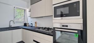 a kitchen with a microwave oven and a sink at Bona Vitae - Attico Vista Mare Castro in Castro di Lecce