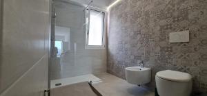 y baño con aseo y ducha acristalada. en Bona Vitae - Attico Vista Mare Castro, en Castro di Lecce