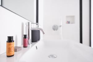 un lavandino in bagno con una bottiglia di crema idratante e uno specchio di I 5 Archi di Via Ducezio a Noto