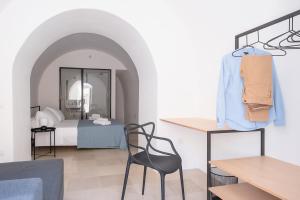 Cette chambre comprend un lit, une chaise et une table. dans l'établissement I 5 Archi di Via Ducezio, à Noto