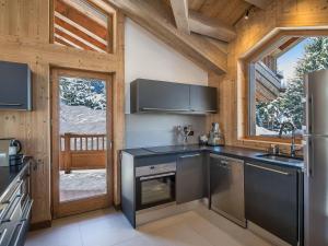 a kitchen with stainless steel appliances in a cabin at Chalet Courchevel 1550, 6 pièces, 10 personnes - FR-1-562-11 in Courchevel