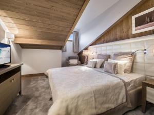 - une chambre avec un grand lit et un plafond en bois dans l'établissement Appartement Courchevel 1550, 3 pièces, 4 personnes - FR-1-562-23, à Courchevel