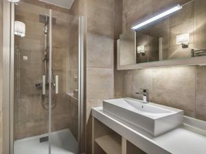 La salle de bains est pourvue d'un lavabo blanc et d'une douche. dans l'établissement Appartement Courchevel 1550, 3 pièces, 4 personnes - FR-1-562-23, à Courchevel