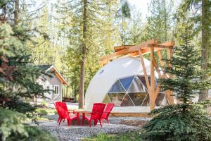 a group of red chairs and a table in front of a tent at Boulder Mountain Resort in Revelstoke