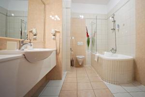 een badkamer met een wastafel, een bad en een toilet bij Zamek Królewski we Wschowie in Wschowa