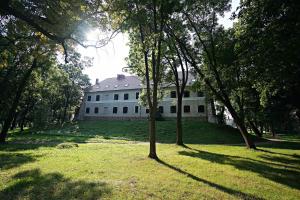 a large white house with trees in front of it at Zamek Królewski we Wschowie in Wschowa