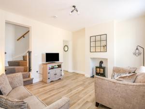 a living room with two couches and a tv at Lily Cottage in Downham Market