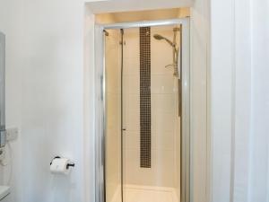 a shower with a glass door in a bathroom at Lily Cottage in Downham Market +22 photos