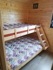 a bedroom with a bunk bed in a log cabin at DOMKI U STRAŻAKA GĄSKI -MORZE in Gąski