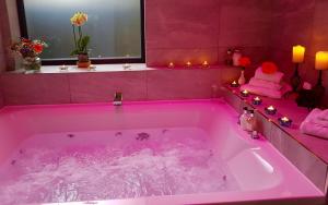 een roze bad met roze verlichting in de badkamer bij Grange Boutique Hotel in Grange Over Sands