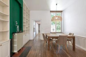 a dining room with a wooden table and chairs at L'élégant de Stanislas in Nancy