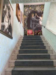 a stairway with a painting of two women on the wall at Hotel Giulietta e Romeo in Casal Palocco