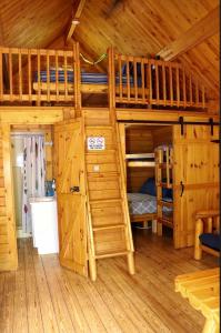a large wooden cabin with bunk beds in it at Katie's Cozy Cabins in Tombstone