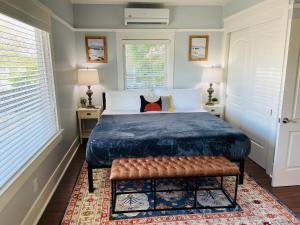 a bedroom with a bed with a bench and two windows at Fern House South Park Craftsman in San Diego