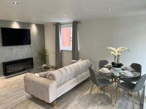 Strada Apartment في إدنبرة: غرفة معيشة مع أريكة كبيرة وطاولة