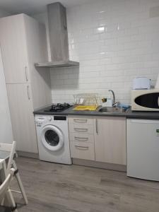 a kitchen with a washing machine and a sink at Mi casa in Plasencia