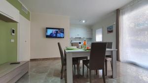 uma cozinha e sala de jantar com mesa e cadeiras em DaniPa House em Portopalo