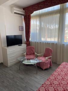 a living room with two chairs and a television at Hotel Giulietta e Romeo in Casal Palocco