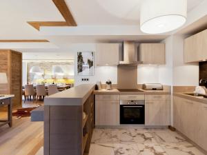 a kitchen with white cabinets and a dining room at Appartement Courchevel 1550, 5 pièces, 12 personnes - FR-1-562-58 in Courchevel