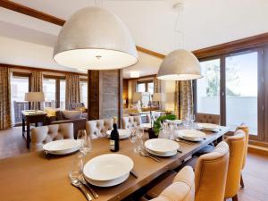 a dining room with a long table with white plates and chairs at Appartement moderne proche pistes, 4 chambres, parking, WiFi - FR-1-562-58 in Courchevel