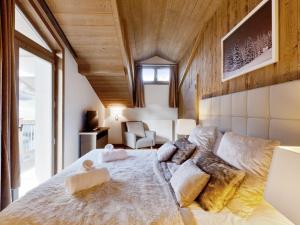 a bedroom with a large bed with pillows on it at Appartement Courchevel 1550, 5 pièces, 12 personnes - FR-1-562-58 in Courchevel