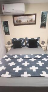 een slaapkamer met een bed met een blauw en wit dekbed bij Central Praias Suíte 5 in Cabo Frio