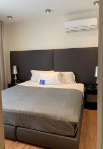a bedroom with a large bed with white sheets at Regency Way Montevideo Hotel in Montevideo