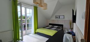 a small bedroom with a bed and a balcony at Willa u Tośka in Kołobrzeg