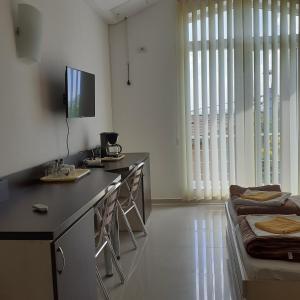 a kitchen with a counter and chairs and a tv at Green House in Eforie Sud
