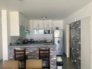 a kitchen with white cabinets and a brick fireplace at Paracas Paracas! 2do Piso Vista al Mar 133 Metros - Sotavento 201 T6 in Paracas