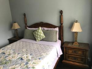 1 dormitorio con 1 cama y 2 mesitas de noche con lámparas en Lake and Bridge View Vacation Home, en West Kelowna