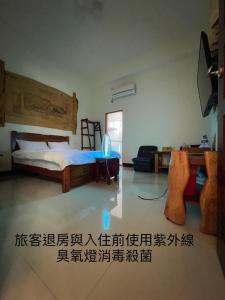 ein Schlafzimmer mit einem Bett und einem TV in einem Zimmer in der Unterkunft Free Time B&B in Taitung