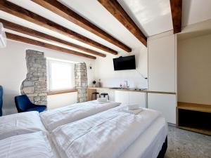 1 dormitorio con 2 camas blancas y TV en Akvatour Apartments Piran, en Piran