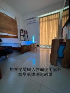 una camera da letto con un letto, una scrivania e un tavolo di Free Time B&B a Città di Taitung Altre 15 foto
