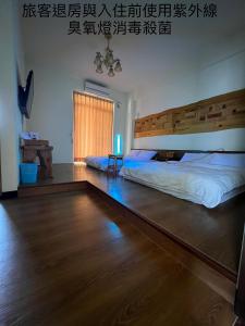 una camera da letto con un letto grande con testiera in legno di Free Time B&B a Città di Taitung