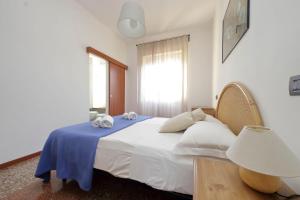 ローマにあるSilvano's Home In Romeのベッドルーム(青い毛布付きの白い大型ベッド1台付)