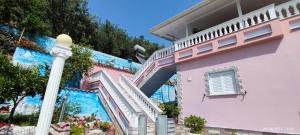 a pink house with a staircase next to it at Phoenice's apartment in Finiq