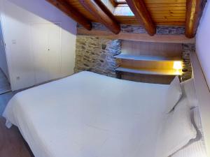 sypialnia z białym łóżkiem i schodami w obiekcie Cal Potablanc w mieście Canillo
