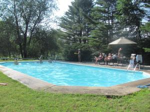 a large swimming pool with people sitting around it at Golden Stage Inn in Proctorsville