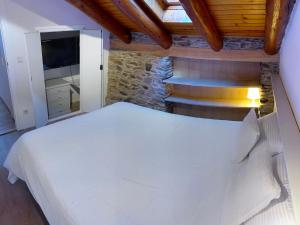 um quarto com uma grande cama branca e escadas em Cal Potablanc em Canillo