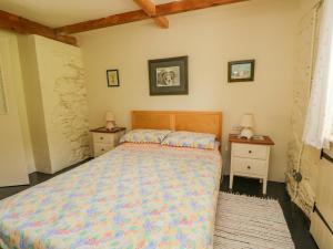 Un dormitorio con una cama y dos mesitas de noche. en The Garden Flat, en Fort William