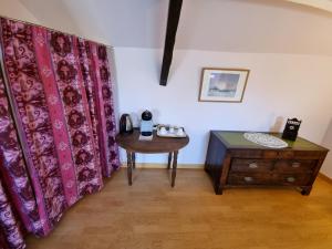 Zimmer mit Vorhängen, einem Holztisch und Holzböden in der Unterkunft Chambre Matisse - Closeries du Golfe in Theix