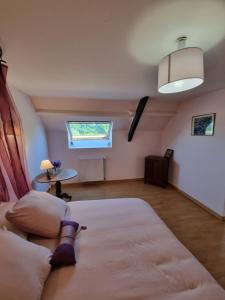 Schlafzimmer mit einem Bett, einem Tisch und einem Fenster in der Unterkunft Chambre Matisse - Closeries du Golfe in Theix
